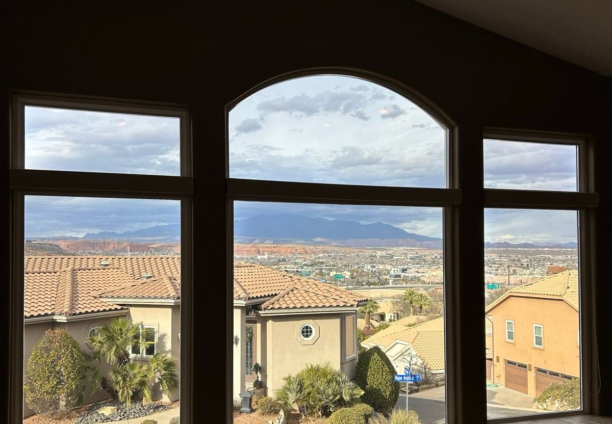 Arched picture windows looking out over tile roofs and the valley to the mountains