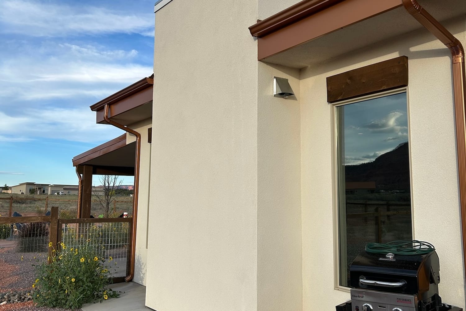 Southern Utah home with clean glass and copper gutters under a bright desert sky