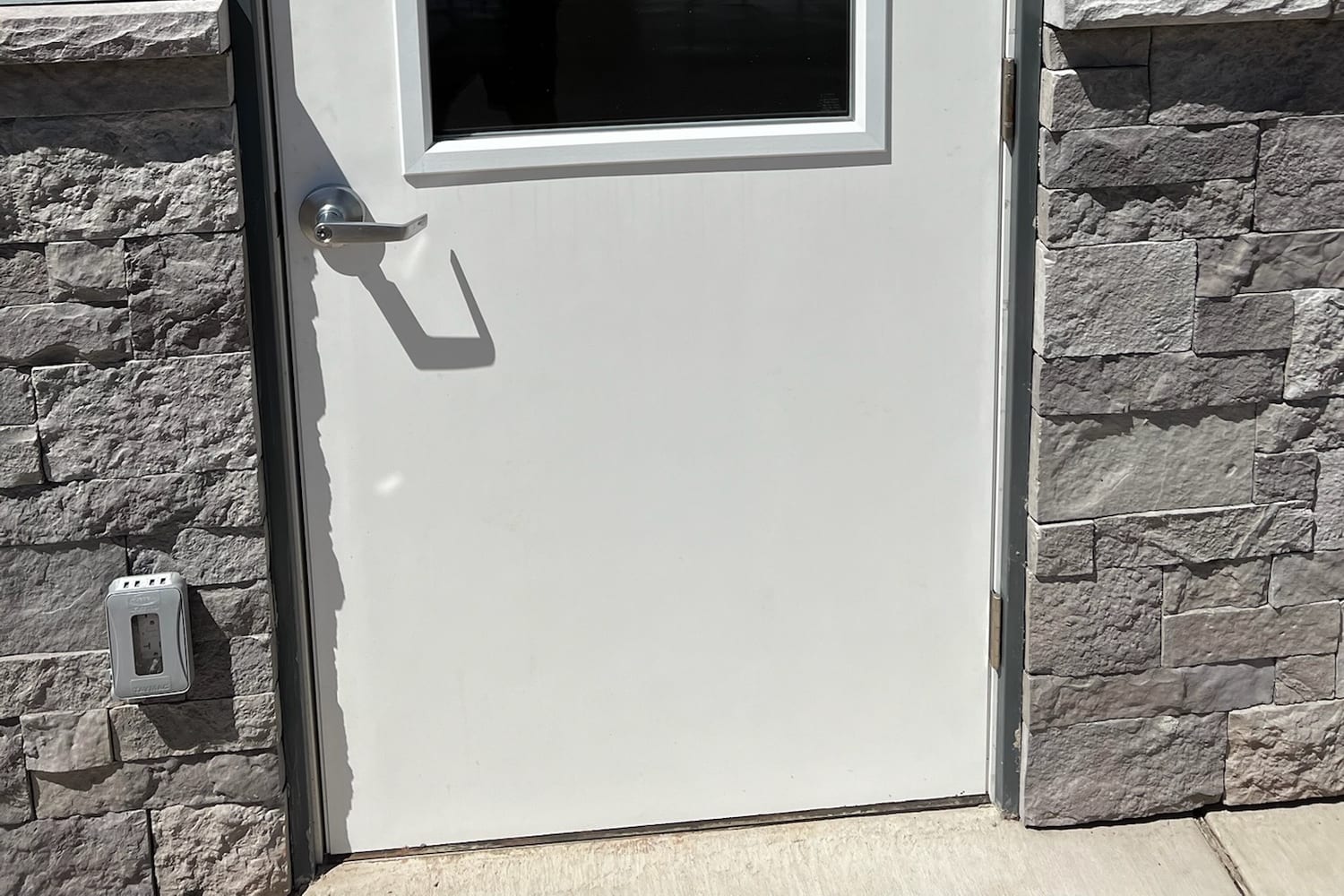 New-build window set in stone and stucco, still carrying construction residue