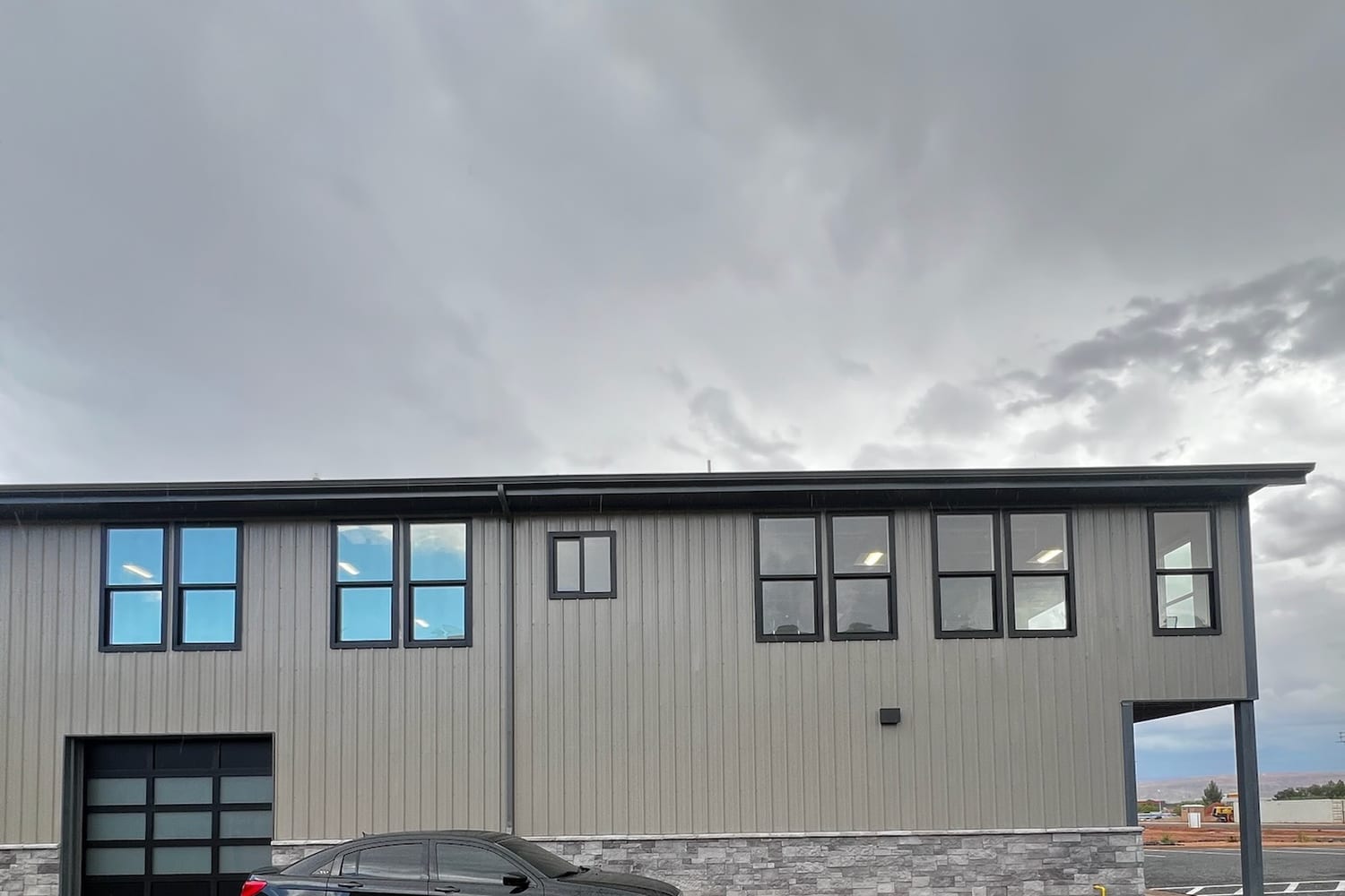 Two-story commercial building with a row of new upper-story windows above a stone base