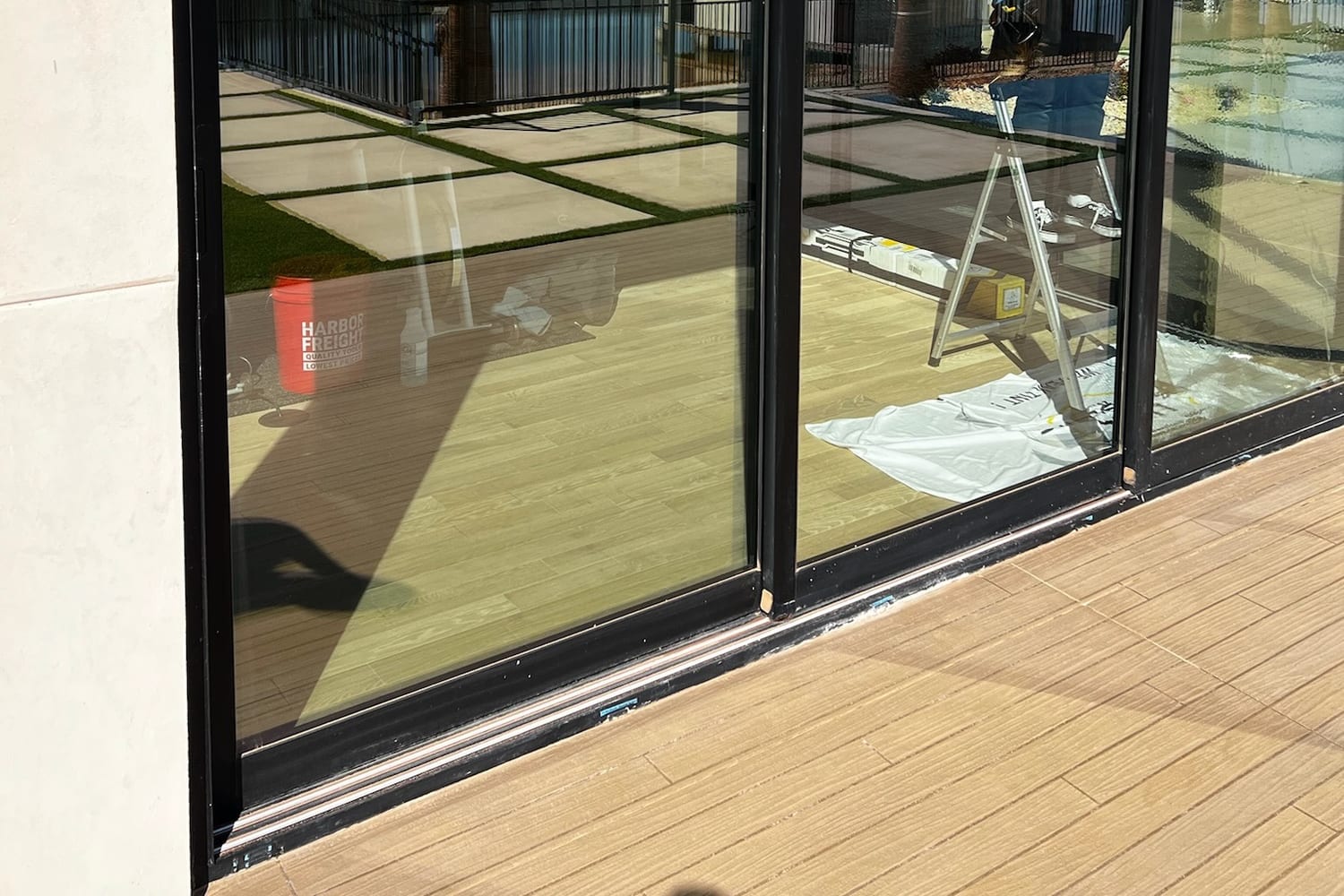 Large sliding glass door with a stepladder and install materials still beside it