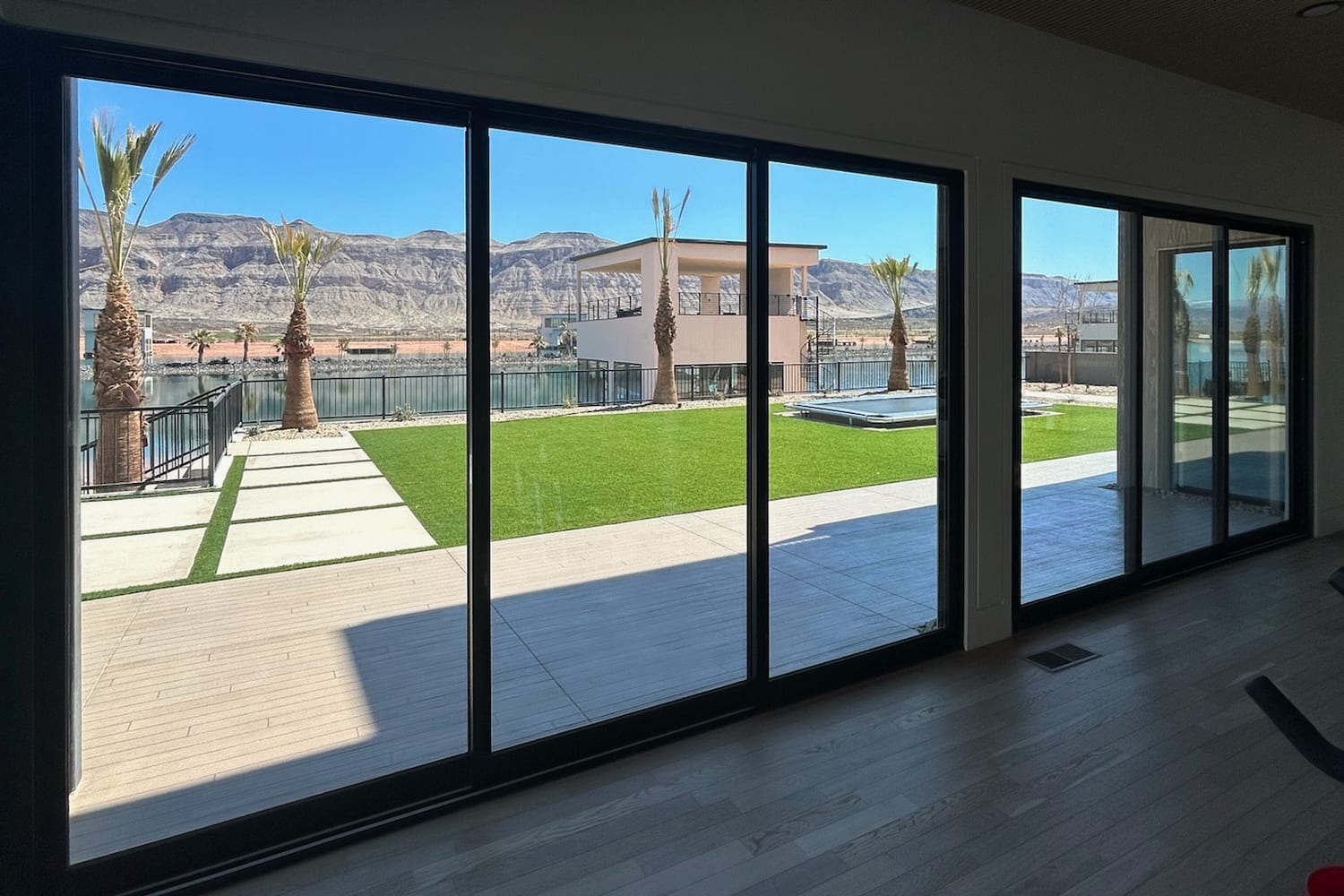 Full-height sliding glass wall with window film, looking out to water and mountains