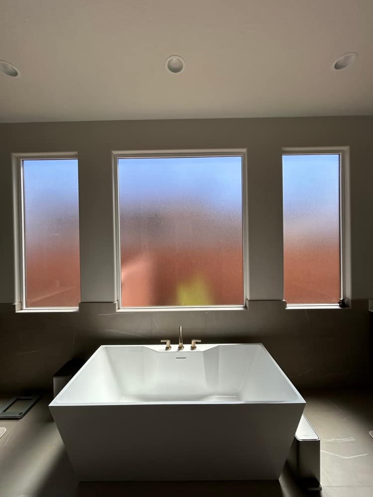 Frosted privacy film on tall bathroom windows