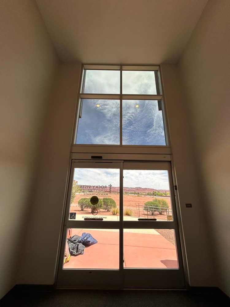 Two-story window wall with tint and a red-rock view
